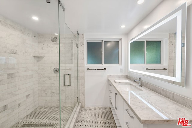 bathroom featuring a shower with shower door and vanity