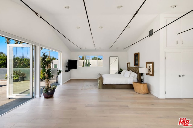 bedroom with light wood-type flooring, access to exterior, and high vaulted ceiling