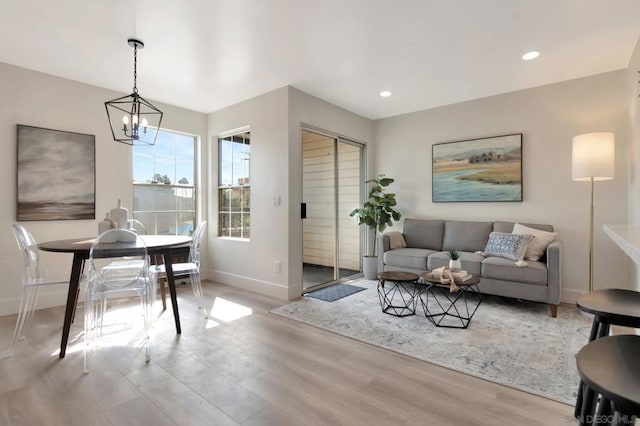 living room featuring light wood-type flooring and a notable chandelier