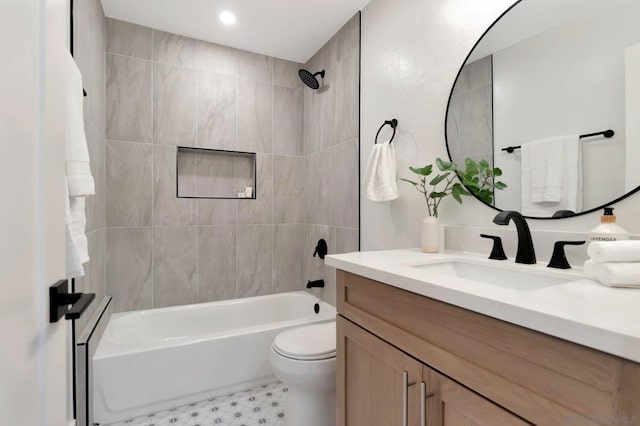 full bathroom featuring tiled shower / bath combo, vanity, and toilet