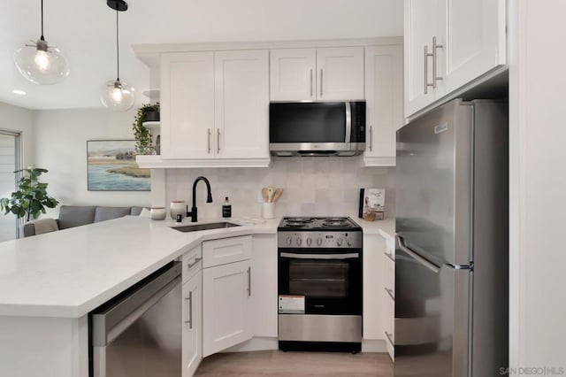 kitchen featuring tasteful backsplash, pendant lighting, sink, white cabinetry, and stainless steel appliances