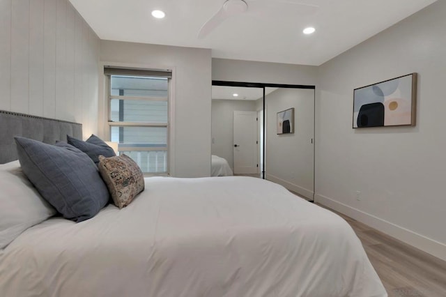 bedroom featuring ceiling fan, multiple windows, a closet, and light hardwood / wood-style flooring