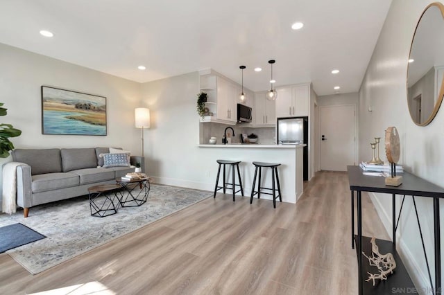 living room with light hardwood / wood-style floors and sink