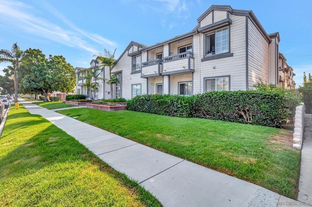 view of front of house with a front yard and a balcony