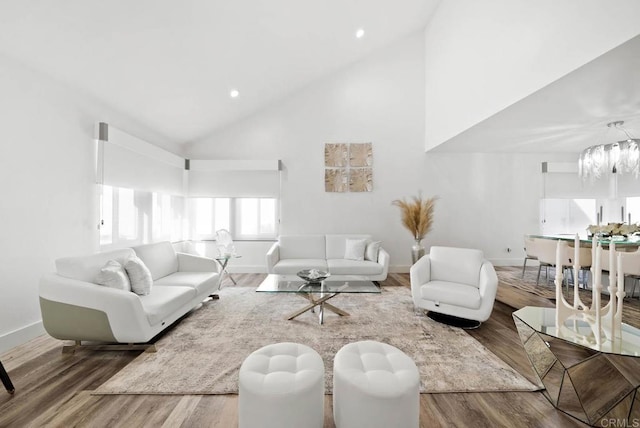 living room featuring an inviting chandelier, hardwood / wood-style flooring, and high vaulted ceiling