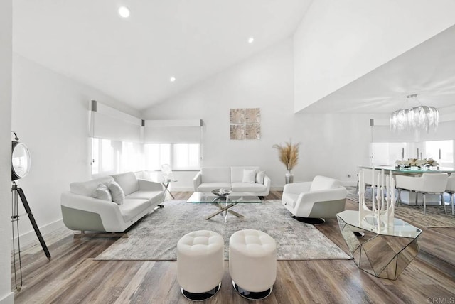 living room featuring light hardwood / wood-style floors, high vaulted ceiling, and a notable chandelier