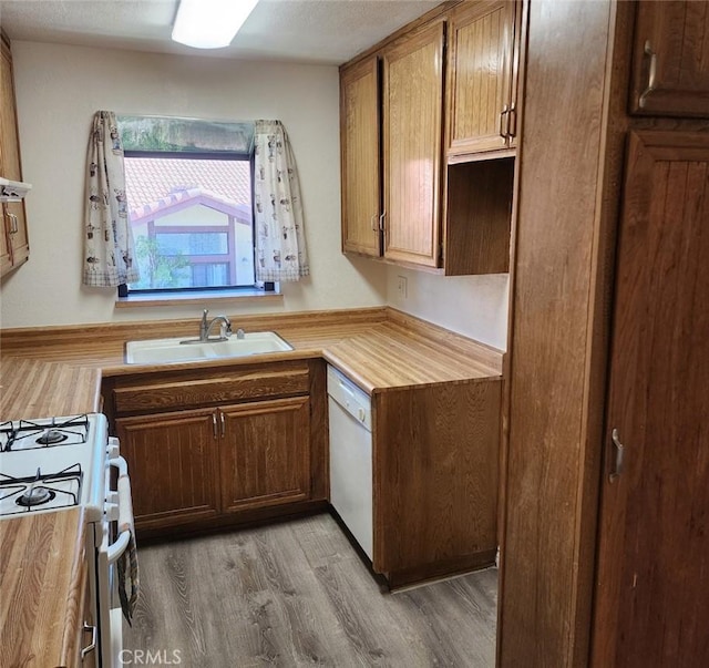 kitchen with sink, white appliances, and light hardwood / wood-style flooring