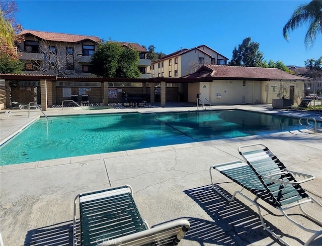 pool with fence and a patio area