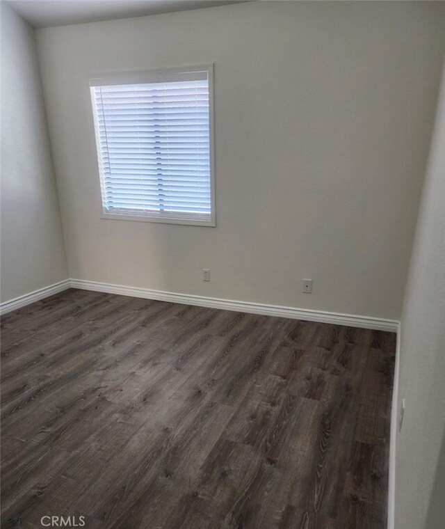 unfurnished room with dark wood-type flooring