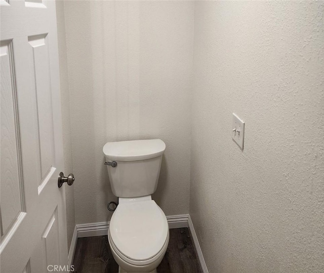 bathroom with toilet and wood-type flooring