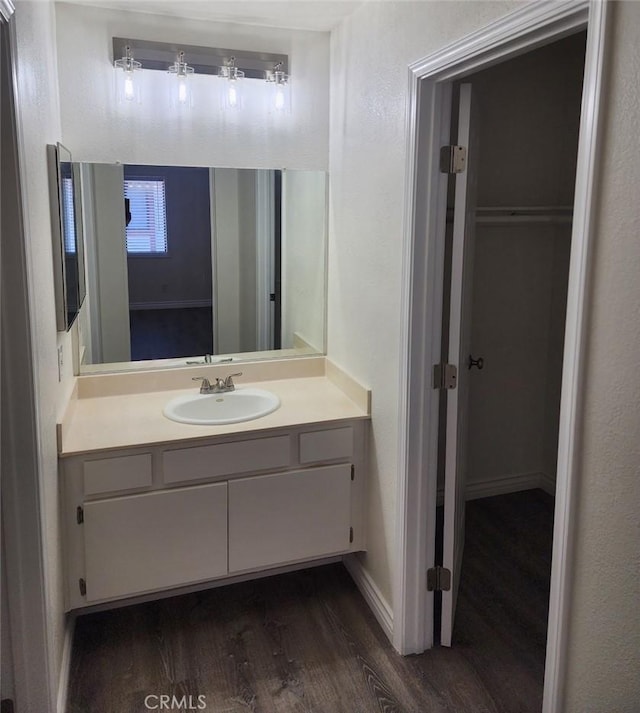bathroom with vanity, baseboards, and wood finished floors