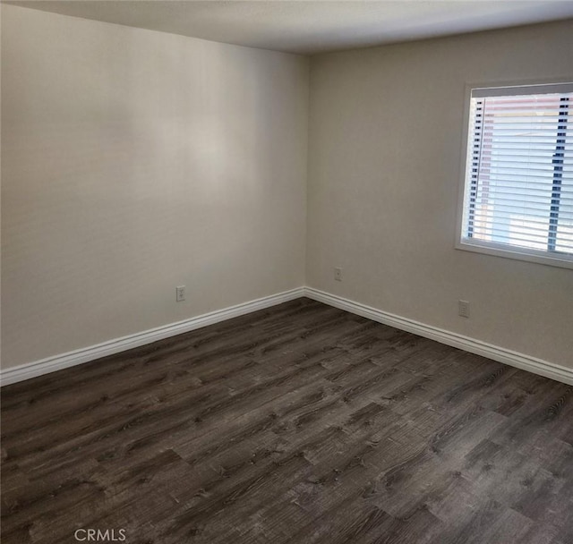 empty room with dark hardwood / wood-style flooring