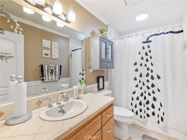 bathroom featuring toilet, vanity, ornamental molding, and tile patterned flooring