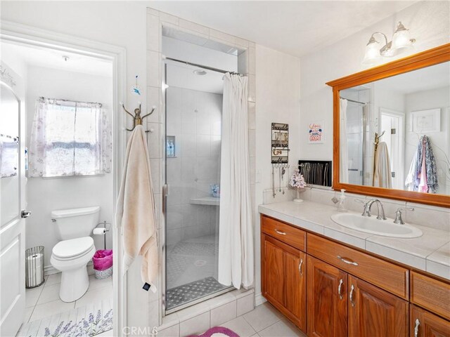 bathroom featuring tile patterned floors, vanity, toilet, and a shower with shower curtain