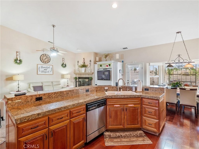 kitchen with ceiling fan, dishwasher, sink, hanging light fixtures, and an island with sink