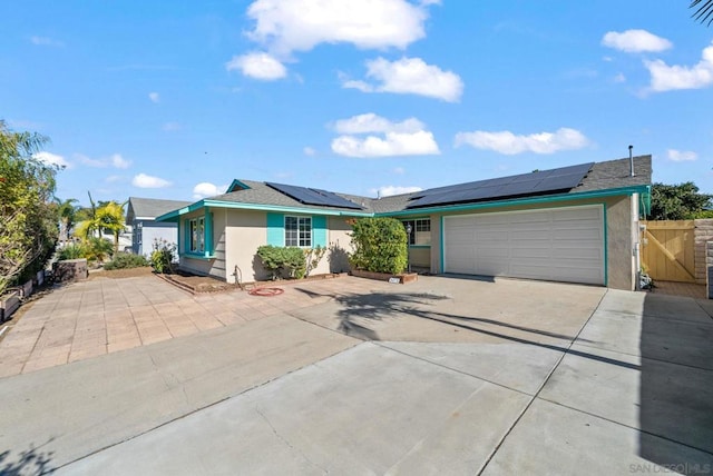 ranch-style house with a garage and solar panels