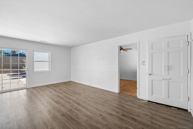 empty room with ceiling fan and dark hardwood / wood-style floors