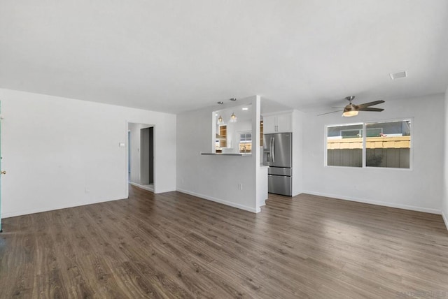 unfurnished living room featuring ceiling fan and dark wood-type flooring