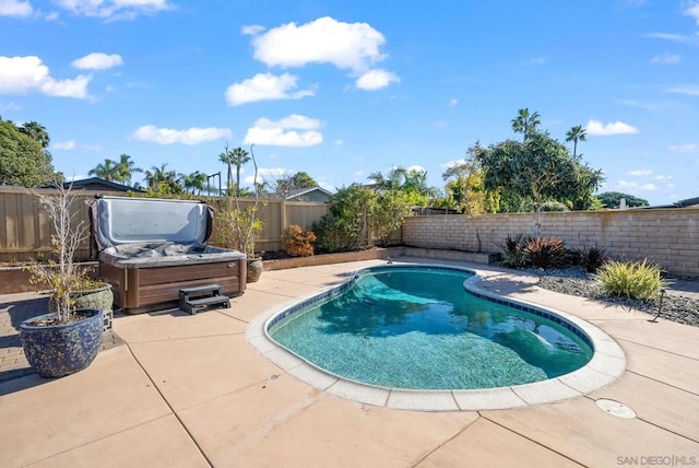 view of swimming pool featuring a hot tub and a patio area