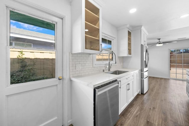 kitchen with tasteful backsplash, appliances with stainless steel finishes, ceiling fan, white cabinets, and sink