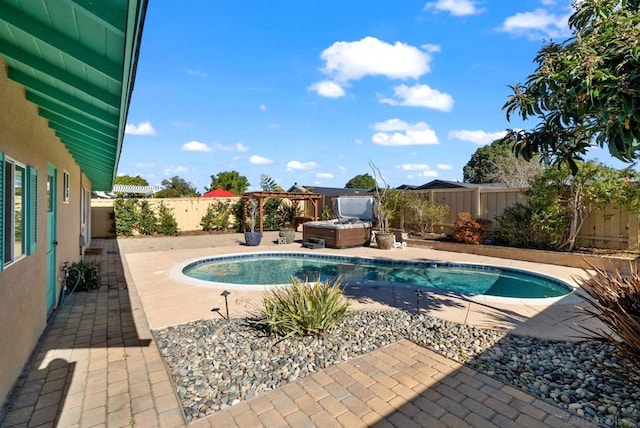 view of swimming pool with a hot tub and a patio area