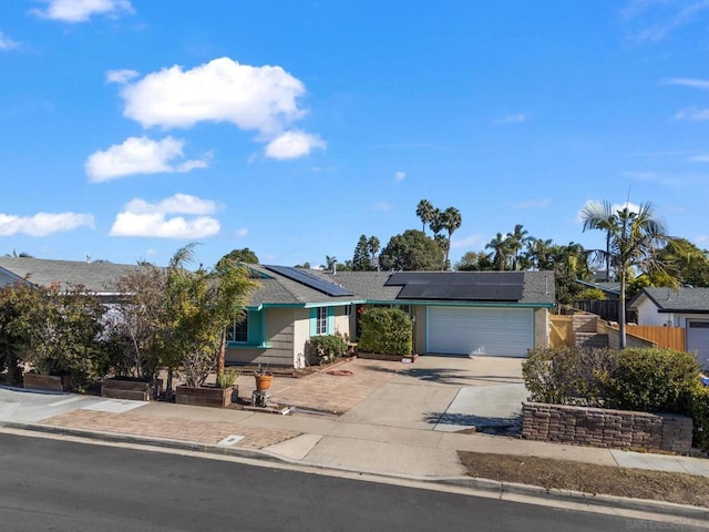 ranch-style house featuring solar panels and a garage