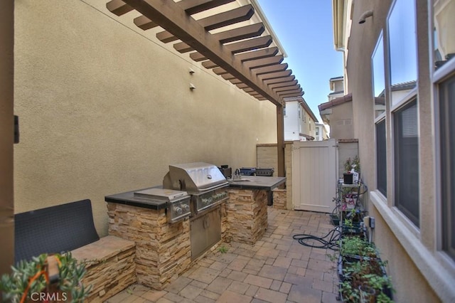 view of patio featuring an outdoor kitchen, grilling area, and a pergola