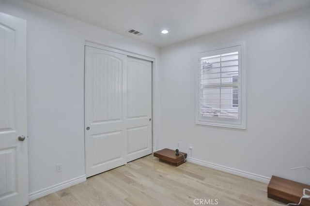 unfurnished bedroom with a closet and light hardwood / wood-style flooring