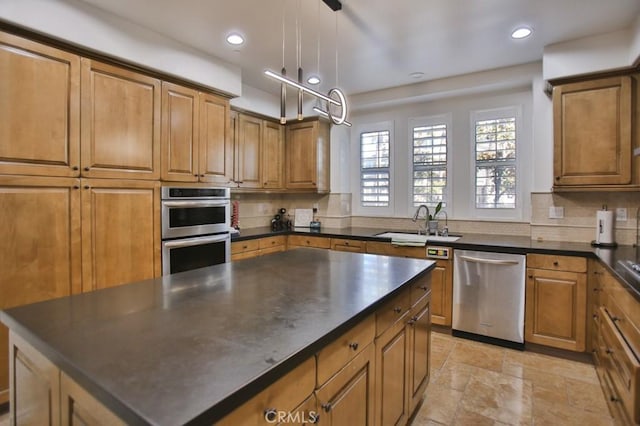 kitchen with sink, pendant lighting, appliances with stainless steel finishes, and tasteful backsplash