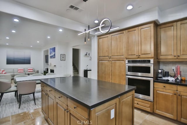 kitchen with decorative backsplash, double oven, a center island, and decorative light fixtures