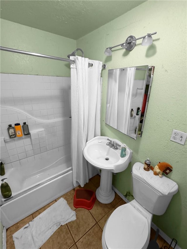 bathroom featuring tile patterned floors, toilet, shower / tub combo, and a textured ceiling