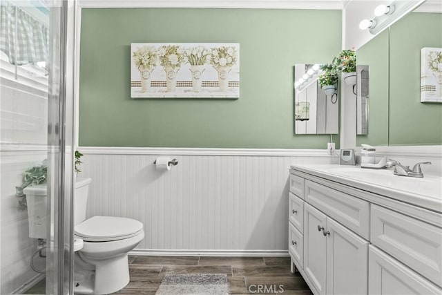 bathroom featuring toilet, vanity, and walk in shower