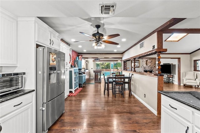 kitchen with ceiling fan, dark stone counters, stainless steel fridge with ice dispenser, white cabinets, and dark hardwood / wood-style flooring