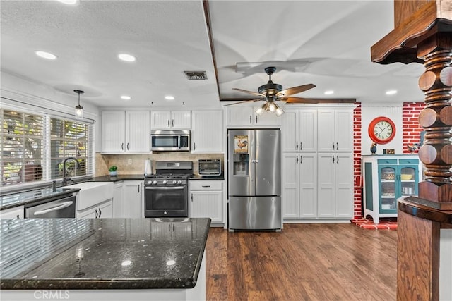 kitchen with decorative light fixtures, decorative backsplash, white cabinetry, dark wood-type flooring, and appliances with stainless steel finishes