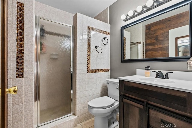 bathroom with tile patterned floors, vanity, tile walls, toilet, and walk in shower