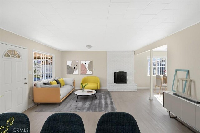 living room with a wealth of natural light, a fireplace, and hardwood / wood-style flooring