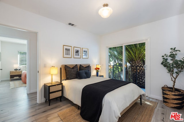 bedroom with wood-type flooring and access to outside