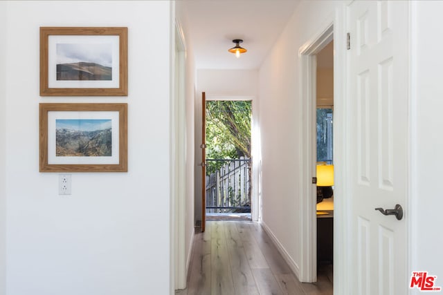 hallway with light hardwood / wood-style floors