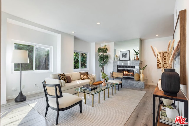 living room with light hardwood / wood-style floors and a tiled fireplace