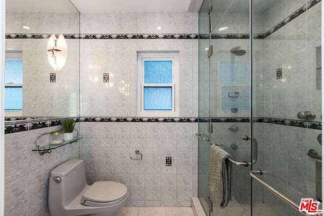 bathroom featuring tile walls, toilet, walk in shower, and tile patterned flooring