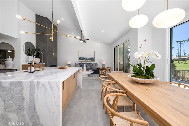 kitchen featuring ceiling fan, light stone counters, pendant lighting, and light brown cabinets