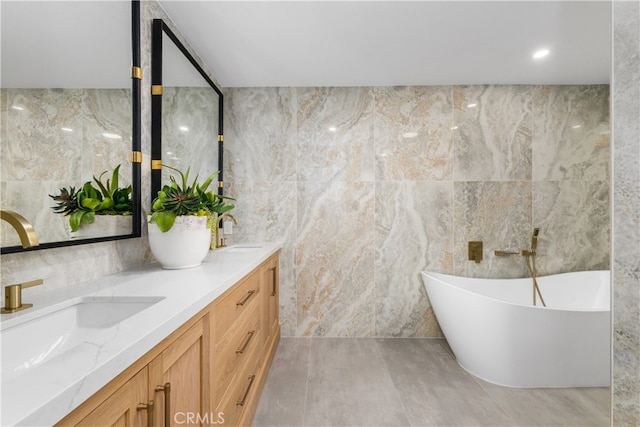 bathroom with vanity, tile walls, and a tub