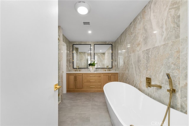 bathroom featuring vanity, tile walls, and a tub