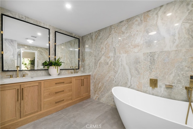 bathroom featuring vanity, tile walls, and a tub