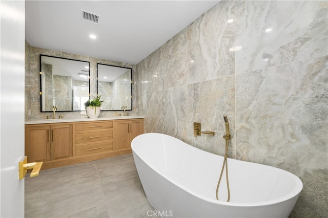 bathroom with tile walls, a tub to relax in, and vanity