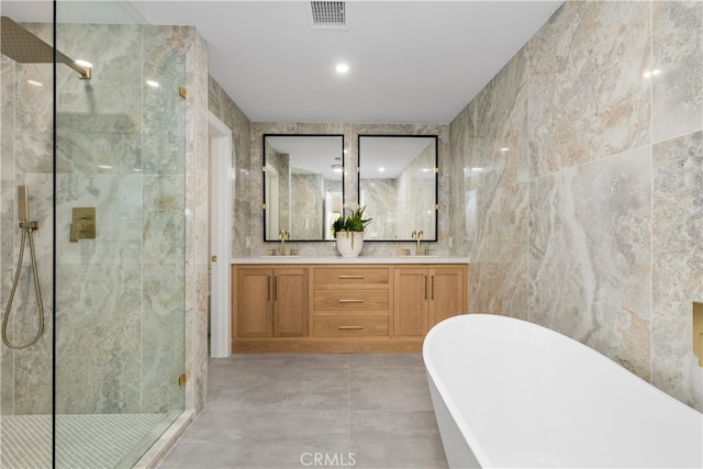 bathroom with tile walls, separate shower and tub, and vanity