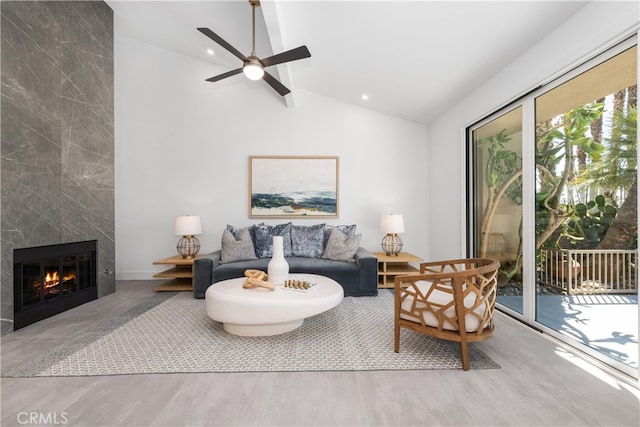 living room with lofted ceiling, ceiling fan, and a high end fireplace