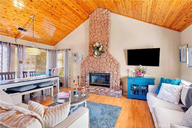 living room featuring wooden ceiling, a large fireplace, light hardwood / wood-style flooring, and high vaulted ceiling