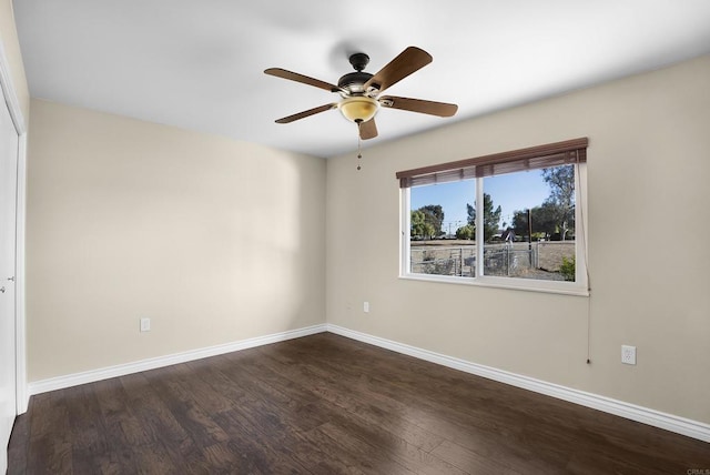 empty room with dark hardwood / wood-style flooring and ceiling fan