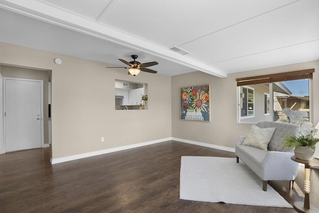 sitting room with dark hardwood / wood-style flooring, ceiling fan, and beamed ceiling